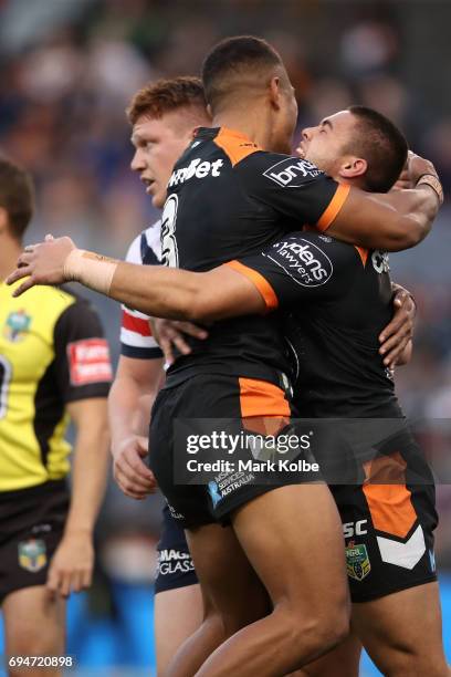 Michael Chee-Kam and Tu'imoala Lolohea of the Tigers celebrate Lolohea scoring a try during the round 14 NRL match between between the Wests Tigers...