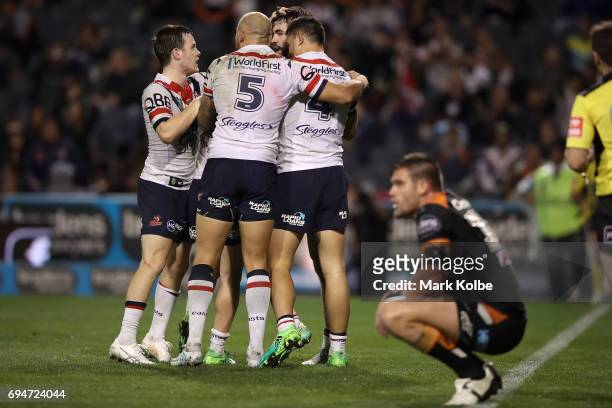 Aidan Guerra of the Roosters celebrates with his team mates after scoring a try during the round 14 NRL match between between the Wests Tigers and...