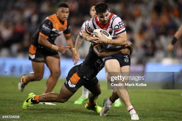 Aidan Guerra of the Roosters is tackled during the round 14 NRL match between between the Wests Tigers and the Sydney Roosters at Campbelltown Sports...