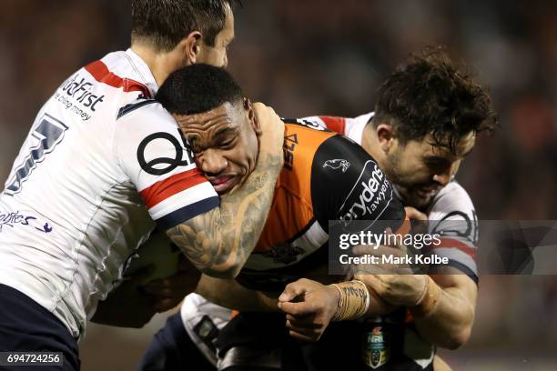 Moses Suli of the Tigers is tackled by Mitchell Pearce and Aidan Guerra of the Roosters during the round 14 NRL match between between the Wests...