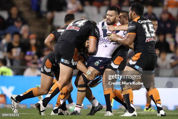 Zane Tetevano of the Roosters is tackled during the round 14 NRL match between between the Wests Tigers and the Sydney Roosters at Campbelltown...