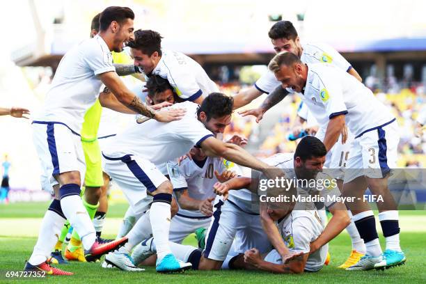 Giuseppe Panico of Italy is swarmed by teammates after scoring the game winning penalty kick during a shootout against Uruguay during the FIFA U-20...
