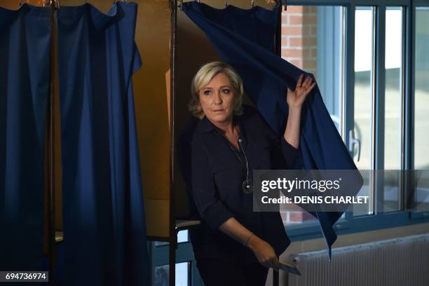 France's far-right National Front leader and parliamentary candidate Marine Le Pen walks out of a voting booth at a polling station in Henin-Beaumont...