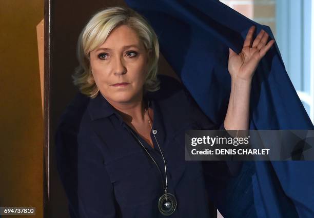 France's far-right National Front leader and parliamentary candidate Marine Le Pen walks out of a voting booth at a polling station in Henin-Beaumont...