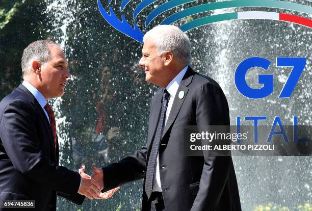 Head of the Environmental Protection Agency Scott Pruitt shakes hand with Italy's Environment Minister Gian Luca Galletti prior to posing for a group...