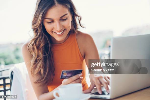 lachende vrouw met creditcard en laptop - online shop stockfoto's en -beelden