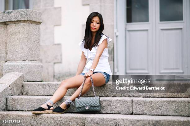 May Berthelot, fashion blogger and Head of Legal at Videdressing.com, wears an Asos white sleeveless top with ruffles, a Levis blue denim short,...