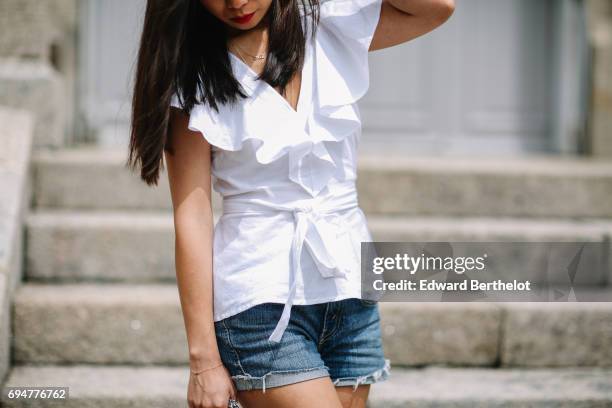 May Berthelot, fashion blogger and Head of Legal at Videdressing.com, wears an Asos white sleeveless top with ruffles, a Levis blue denim short,...