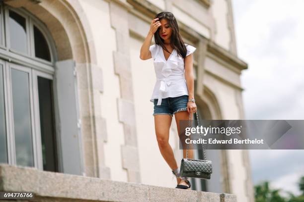 May Berthelot, fashion blogger and Head of Legal at Videdressing.com, wears an Asos white sleeveless top with ruffles, a Levis blue denim short,...