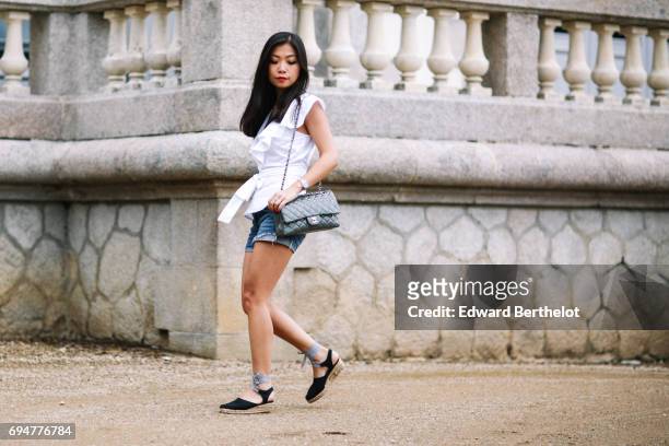 May Berthelot, fashion blogger and Head of Legal at Videdressing.com, wears an Asos white sleeveless top with ruffles, a Levis blue denim short,...