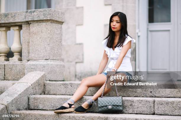 May Berthelot, fashion blogger and Head of Legal at Videdressing.com, wears an Asos white sleeveless top with ruffles, a Levis blue denim short,...