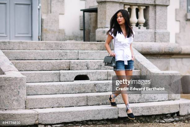 May Berthelot, fashion blogger and Head of Legal at Videdressing.com, wears an Asos white sleeveless top with ruffles, a Levis blue denim short,...