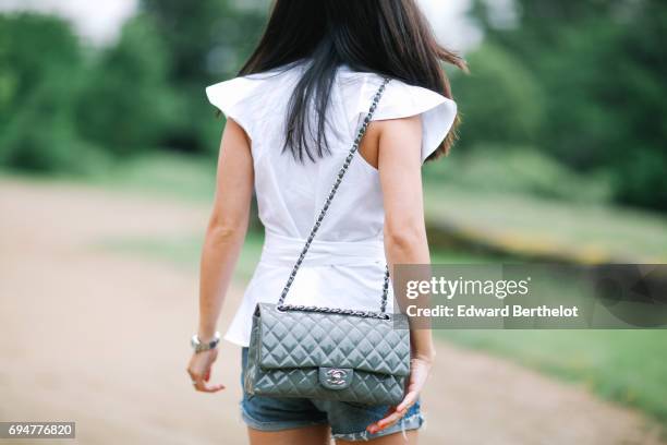 May Berthelot, fashion blogger and Head of Legal at Videdressing.com, wears an Asos white sleeveless top with ruffles, a Levis blue denim short,...