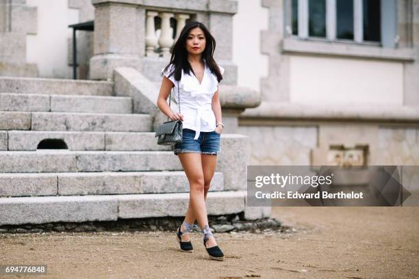 May Berthelot, fashion blogger and Head of Legal at Videdressing.com, wears an Asos white sleeveless top with ruffles, a Levis blue denim short,...