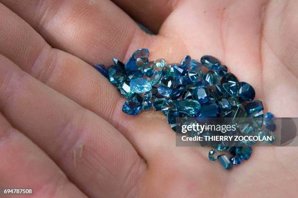 Nicolas Leger, an amateur gemologist, holds sapphires in Issoire, on May 27, 2017. / AFP PHOTO / Thierry Zoccolan