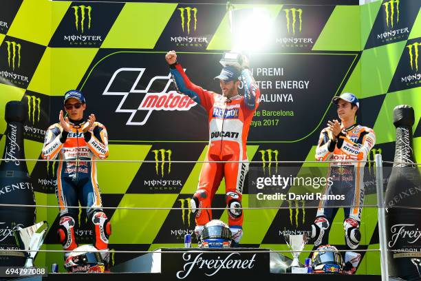 Andrea Dovizioso of Italy and Ducati Team celebrates on the podium next to Marc Marquez of Spain and Repsol Honda Team second and Dani Pedrosa of...