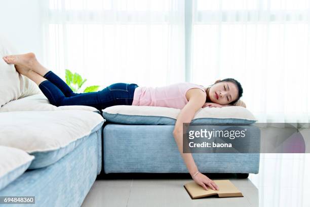 donna che dorme sul divano con libro - china foto e immagini stock