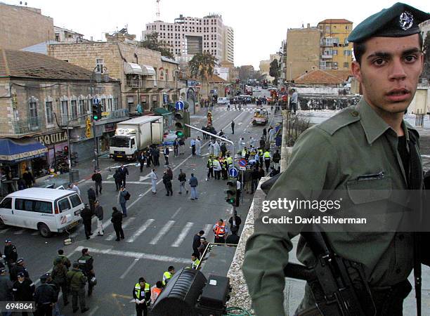 An Israeli policeman stands guard on a rooftop January 27, 2002 over Jerusalems Jaffa Road where a Palestinian woman suicide bomber blew herself up....