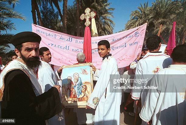 Egyptian Coptic Orthodox priests and pilgrims walk in a procession January 26, 2002 through the Christian village of Deir Abu Hennis to commemorate...