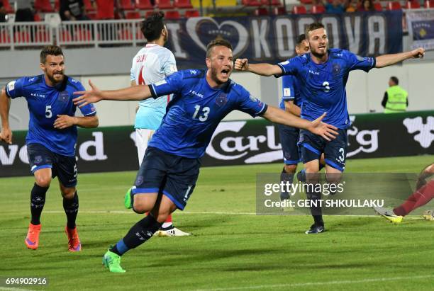 Kosovo's Amir Rrahmani celebrates with teammates Enis Alushi and Fidan Aliti after scoring during the FIFA World Cup 2018 qualification football...