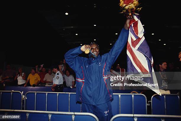 British boxer Audley Harrison proudly displays his gold medal whilst holding a union flag after winning the final of the Men's Super heavyweight...