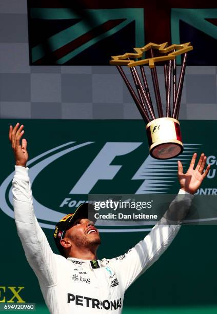 Lewis Hamilton of Great Britain and Mercedes GP celebrates on the podium after winning the Canadian Formula One Grand Prix at Circuit Gilles...