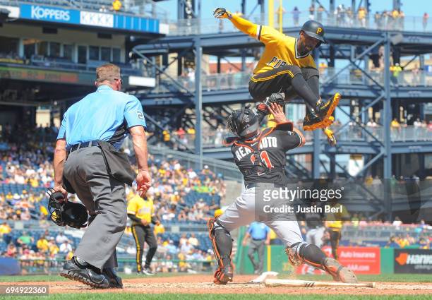 Andrew McCutchen of the Pittsburgh Pirates is tagged out at home plate by J.T. Realmuto of the Miami Marlins as part of a double play in the sixth...