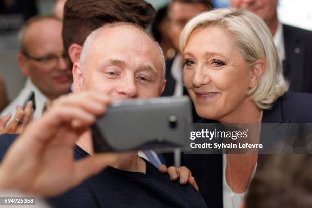 French National Front political party leader and candidate for French legislative elections, Marine Le Pen poses for selfie with supporter after the...