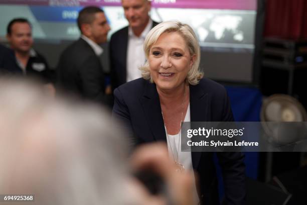French National Front political party leader and candidate for French legislative elections, Marine Le Pen poses is greeted by supporters after the...