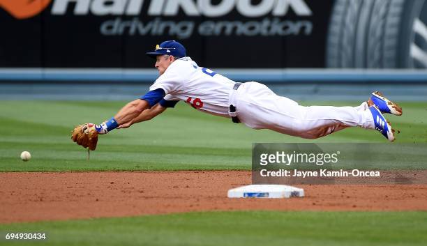 Chase Utley of the Los Angeles Dodgers dives for a single by Jose Peraza of the Cincinnati Reds in the second inning of the game at Dodger Stadium on...