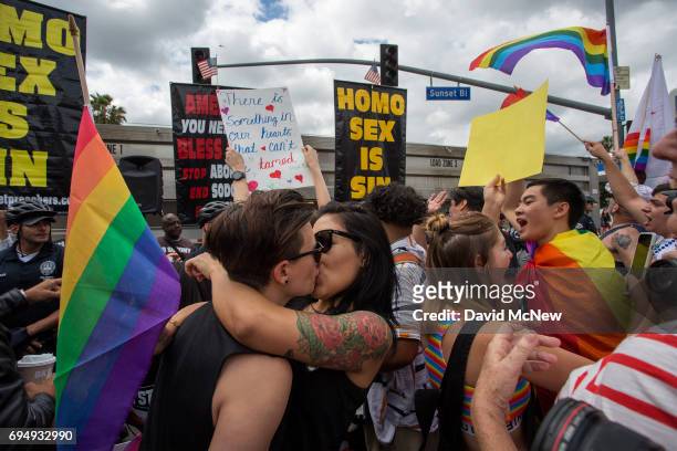 Women kiss in defiance of hateful speech from provocative street preachers at the #ResistMarch during the 47th annual LA Pride Festival on June 11 in...