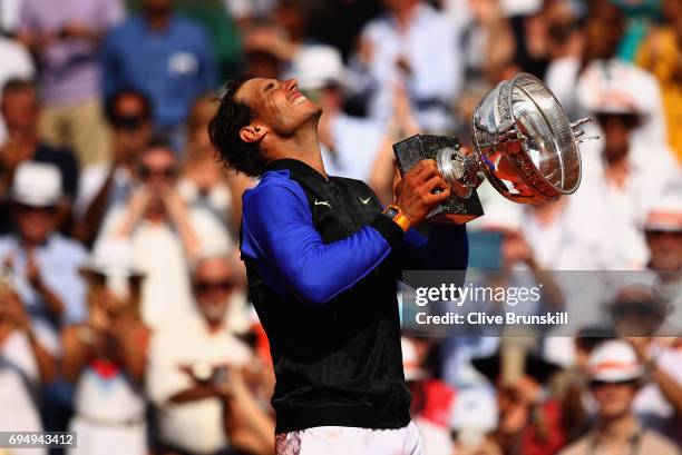 Rafael Nadal of Spain celebrates victory with the trophy following the mens singles final against Stan Wawrinka of Switzerland on day fifteen of the...