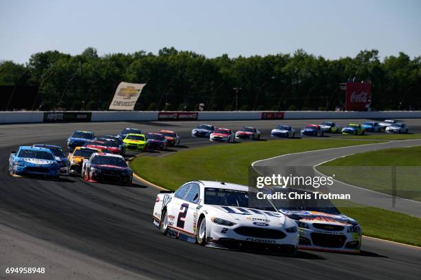 Brad Keselowski, driver of the Miller Lite Ford, and Chase Elliott, driver of the SunEnergy1 Chevrolet, lead a pack of cars during the Monster Energy...