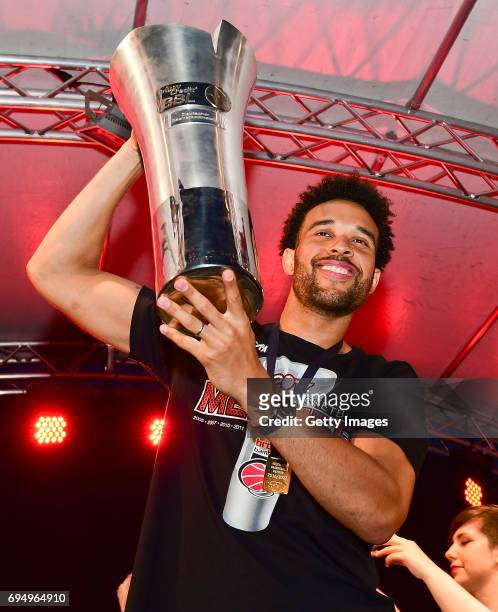 Elias Harris of Brose Bamberg raises the trophy of the German basketball championship at Maxplatz on June 11, 2017 in Bamberg, Germany.