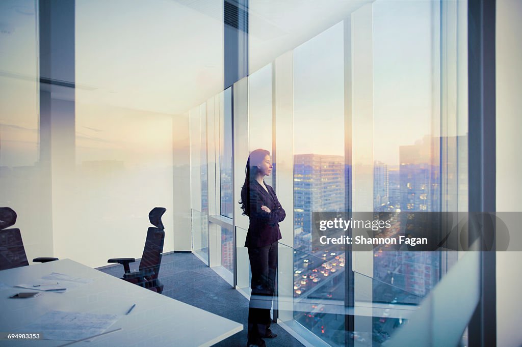 Businesswoman looking out window in meeting room