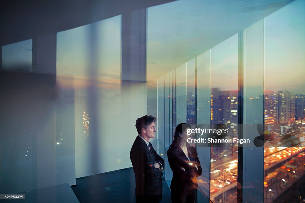 Business colleagues looking out window in office