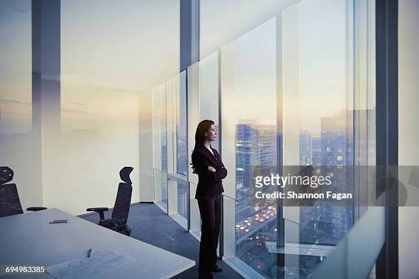 businesswoman looking out window in meeting room - chief executive officer stock-fotos und bilder