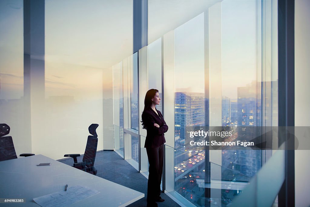 Businesswoman looking out window in meeting room