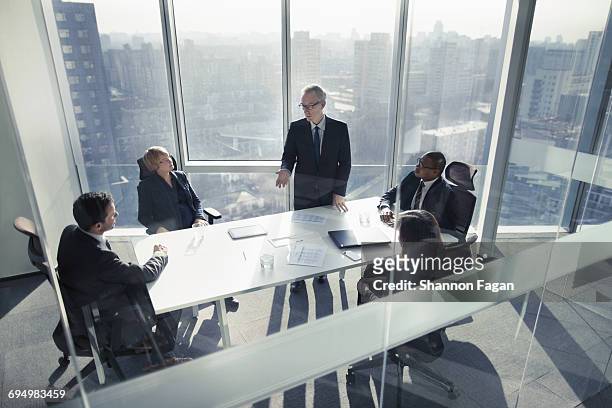businessman talking to colleagues in meeting - business meeting stockfoto's en -beelden