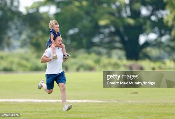 Mike Tindall carries daughter Mia Tindall on his shoulders as they attend the Maserati Royal Charity Polo Trophy Match during the Gloucestershire...