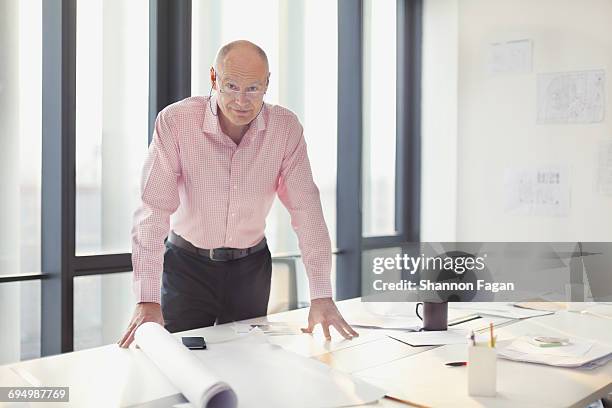 portrait of man at work table in office studio - pink collared shirt stock pictures, royalty-free photos & images