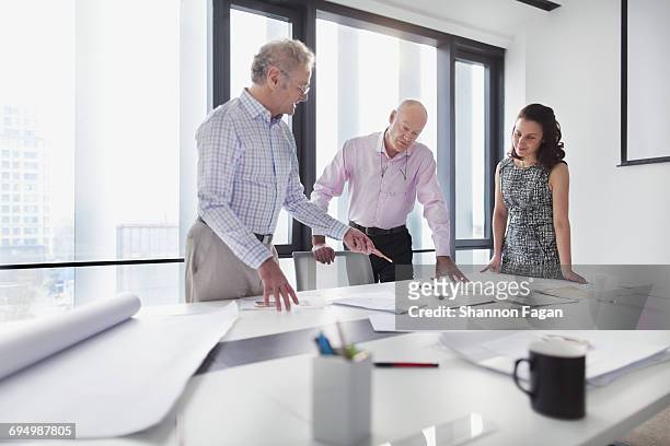 colleagues talking about layouts in office studio - asian man white background stock pictures, royalty-free photos & images