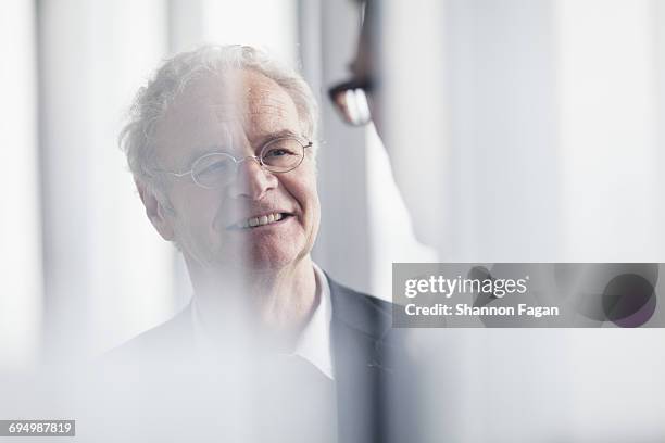 men talking behind glass wall in office space - beijing office stock pictures, royalty-free photos & images