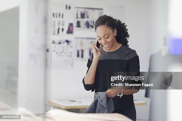 woman talking on phone in fashion design studio - east asia stock pictures, royalty-free photos & images