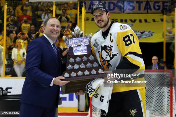 Sidney Crosby of the Pittsburgh Penguins poses for a photo with NHL Commissioner Gary Bettman as he is presented with the Conn Smythe Trophy after...
