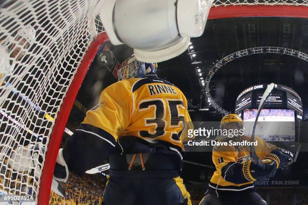 Patric Hornqvist of the Pittsburgh Penguins shoots the puck off goaltender Pekka Rinne of the Nashville Predators which goes into the net for a goal...