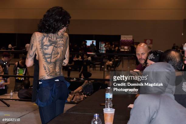 Participant enters the tattoo contest for best back piece during day three of the "19th Annual Northern Ink Xposure Tattoo Convention" at the Metro...