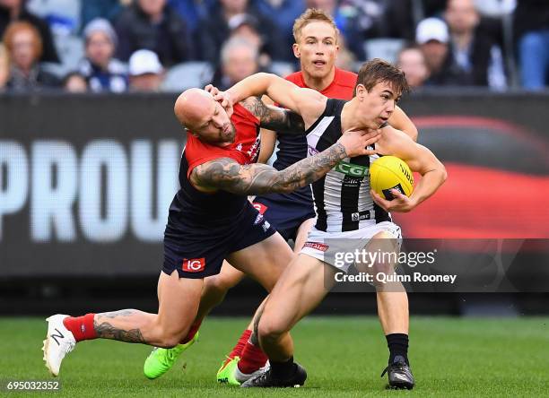 Callum Brown of the Magpies is tackled by Nathan Jones of the Demons during the round 12 AFL match between the Melbourne Demons and the Collingwood...