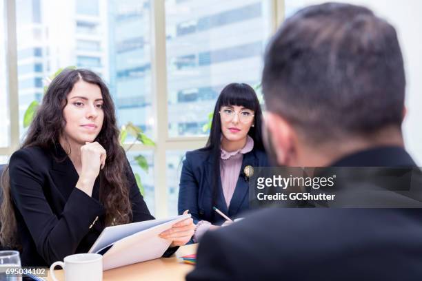 modern female business executive taking the interview of a young businessman - middle east people stock pictures, royalty-free photos & images