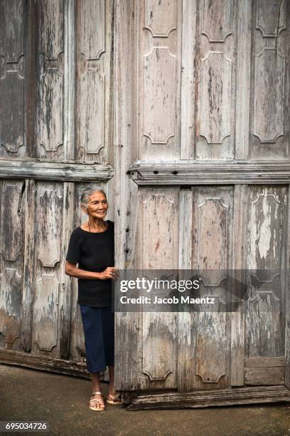 woman standing next to old wooden church doors. - siquijor islands stock pictures, royalty-free photos & images